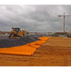 High visibility orange geotextile membrane installed beneath an access road on a construction site