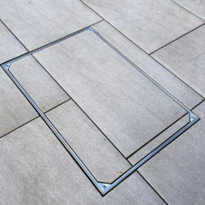 Triple sealed recessed manhole cover installed flush within patio paving for a discreet architectural finish.