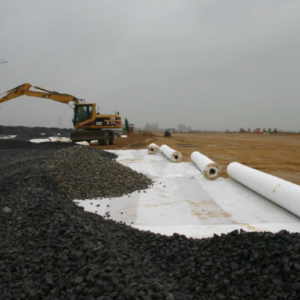 Non-woven geotextile installed beneath aggregate during road construction to provide separation and improve ground stability.